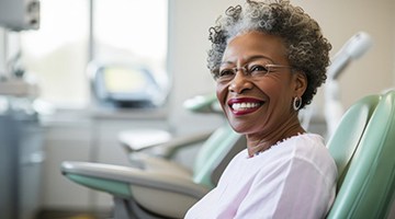 Patient in Newark smiling with implanted dentures