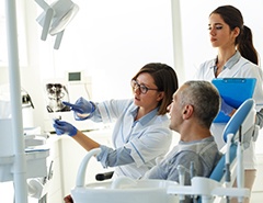 Patient in Newark talking to dentist about implanted dentures