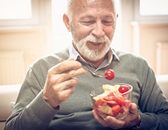 Patient in Newark eating with implanted dentures