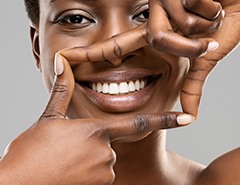 Woman framing her beautiful smile with 4 fingers