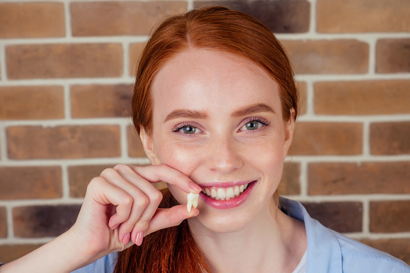 closeup of woman holding tooth extraction