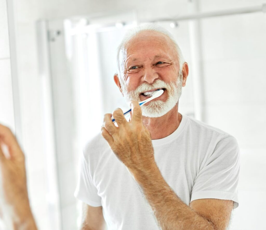 A man looking in the mirror brushing his teeth